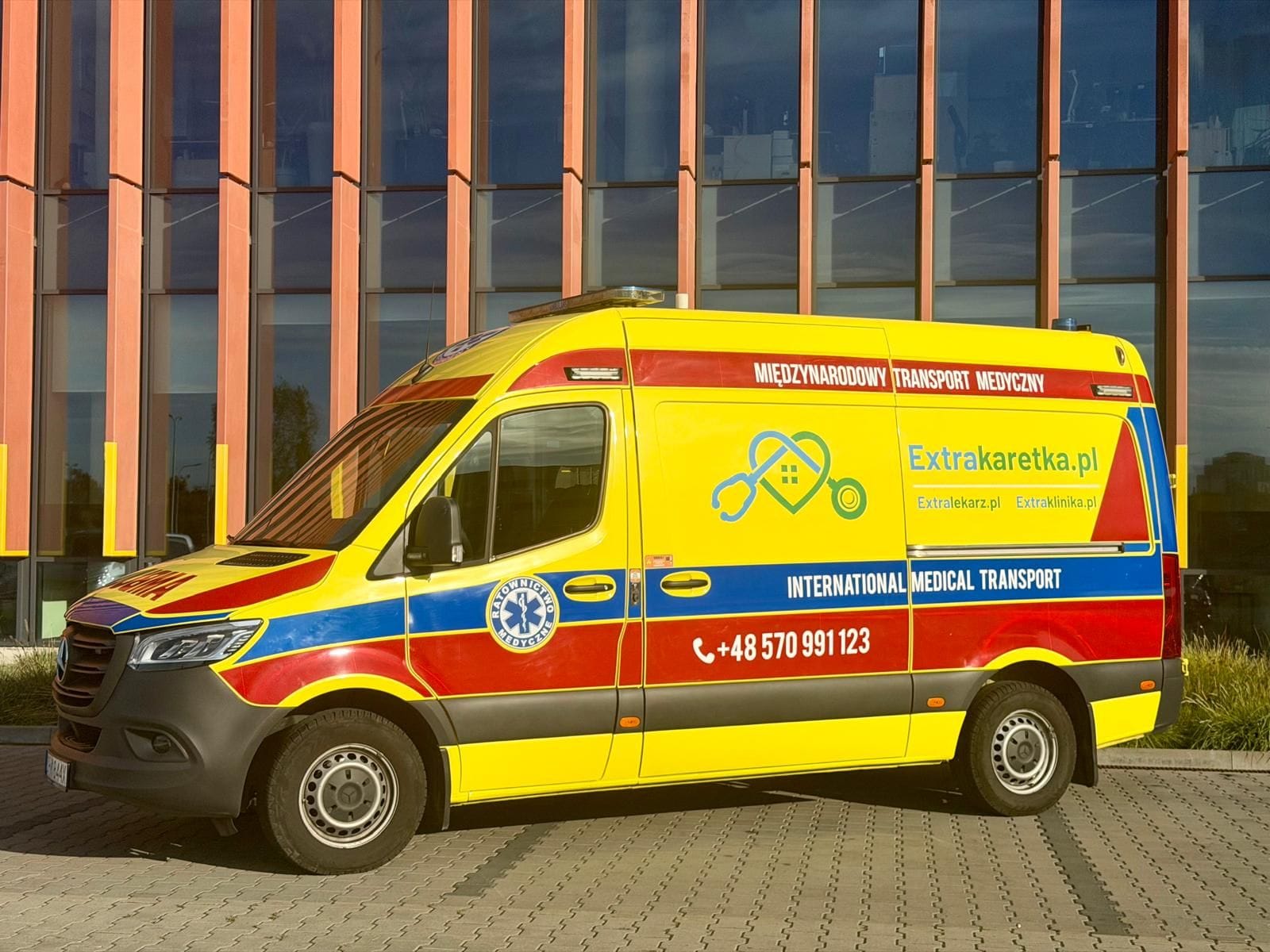 Ambulans Mercedes Sprinter Extrakaretka.pl z boku — oznakowanie międzynarodowego transportu medycznego