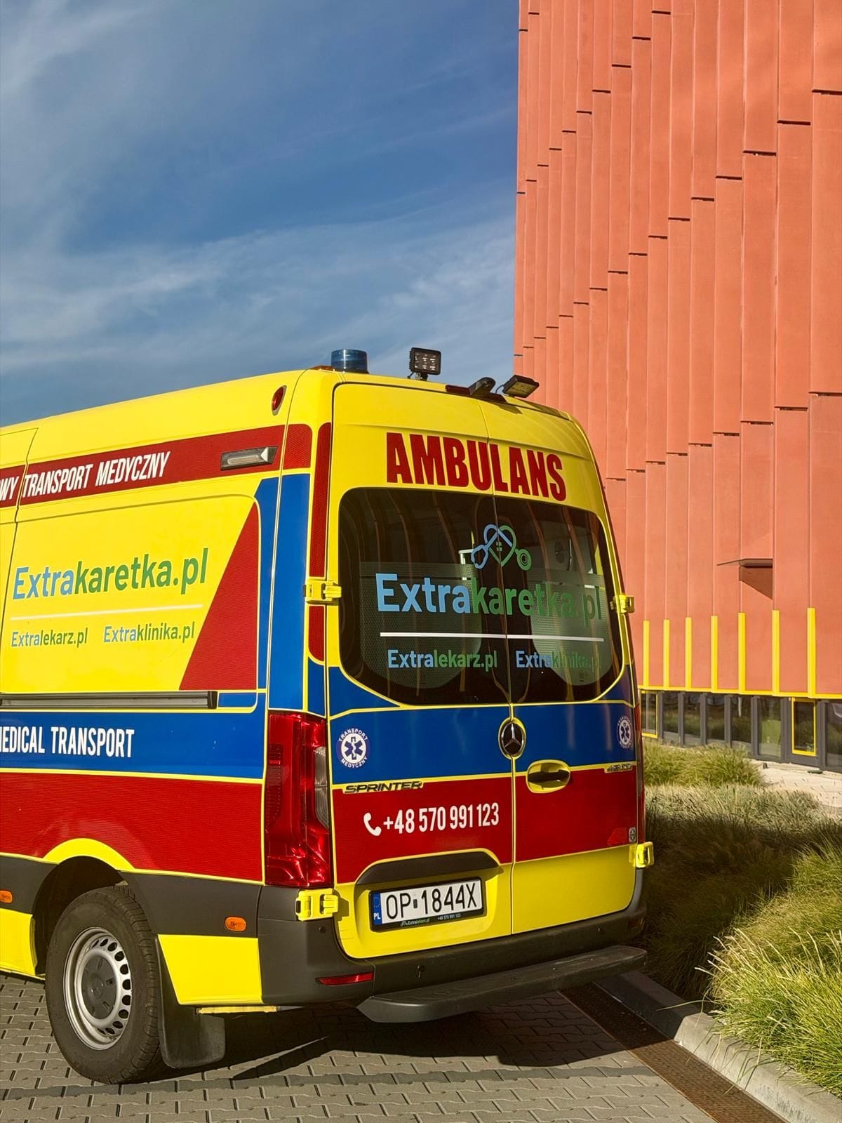 Tył ambulansu Extrakaretka.pl z oznakowaniem i numerem telefonu 570 991 123