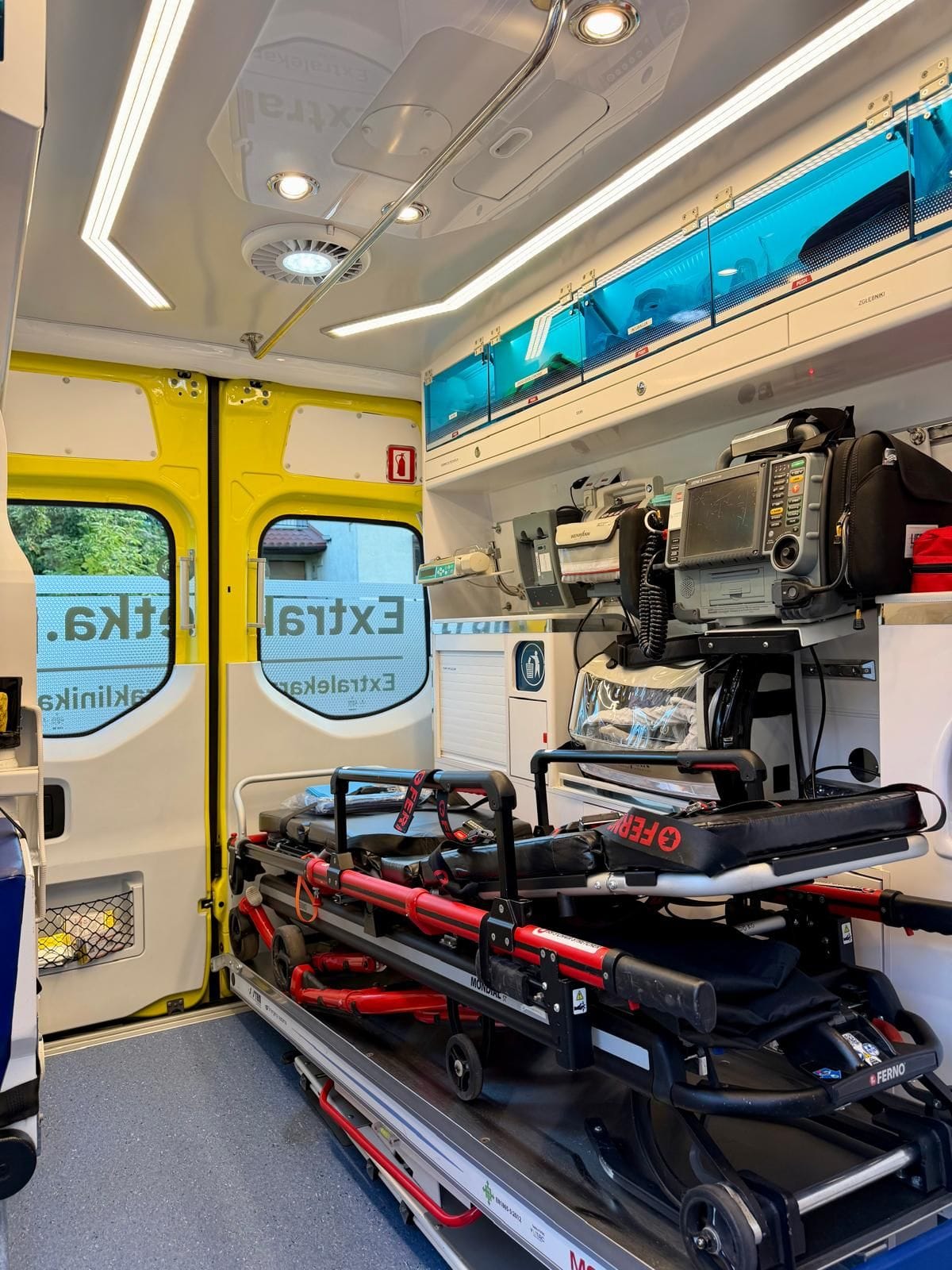 Innenraum eines Krankenwagens von Extrakaretka.pl: Trage mit Fahrgestell, Defibrillator und Beatmungsgerät
