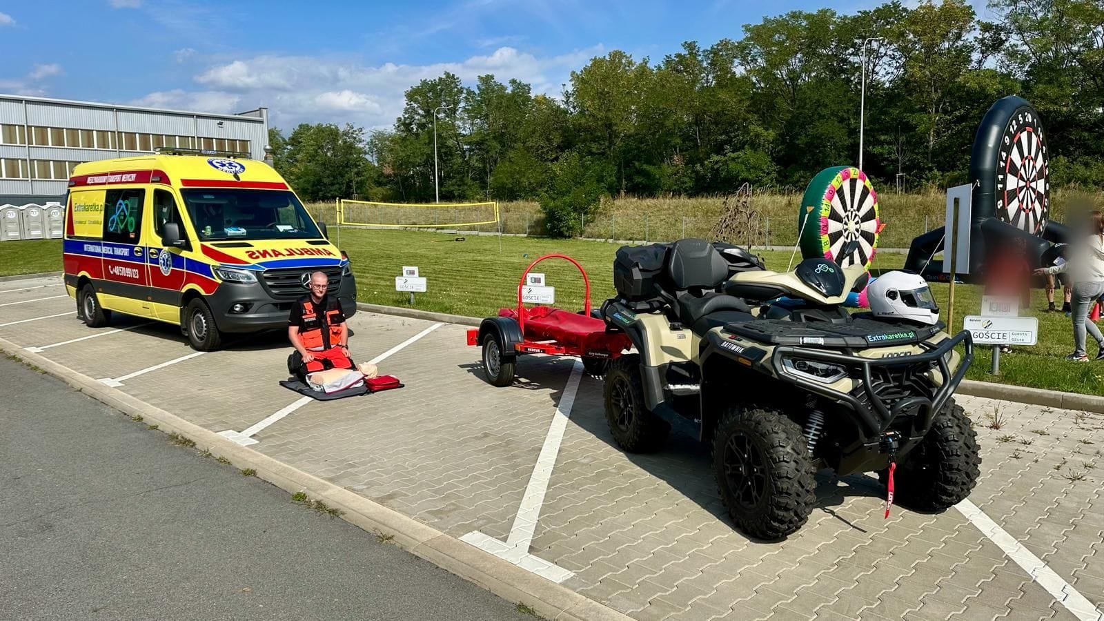 Ratownik medyczny Extrakaretka.pl z fantomem do resuscytacji, ambulans i quad ratowniczy na pikniku firmowym